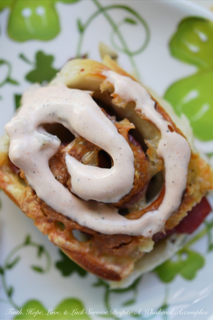 Corned Beef Pizza Swirls - St. Patrick's Day calls for a special appetizer, and these corned beef pizza swirls are that appetizer. They have just the right amount of corned beef lunchmeat and cheese rolled up inside of caraway seed-studded pizza dough. Add a swirl of homemade thousand island dressing on top and let the festive holiday celebration begin.