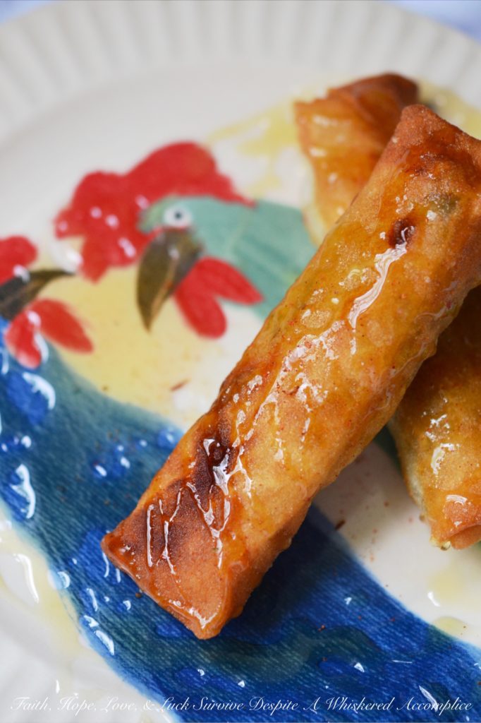 Cajun Shrimp Egg Rolls - Asian meets Cajun in this easy-to-make Cajun Shrimp Egg Roll recipe. Use store-bought spring roll shells, cellophane noodles, and cole slaw mix to make flavorful crunchy egg rolls, with the addition of chopped shrimp and Cajun seasoning. Serve with honey for the perfect sweet and spicy flavor combination.