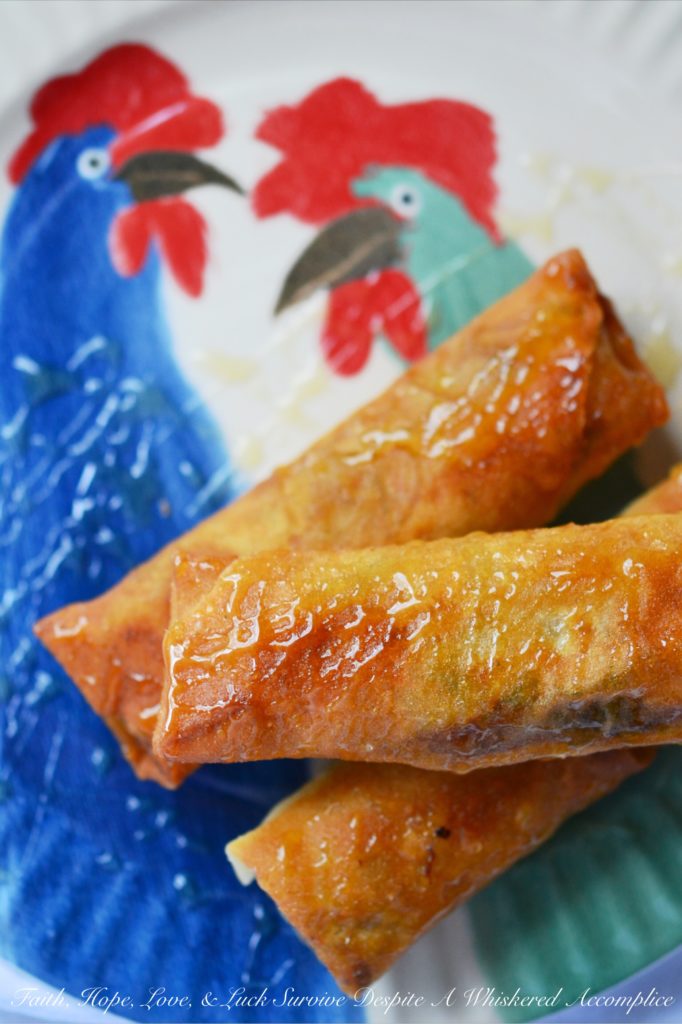 Cajun Shrimp Egg Rolls - Asian meets Cajun in this easy-to-make Cajun Shrimp Egg Roll recipe. Use store-bought spring roll shells, cellophane noodles, and cole slaw mix to make flavorful crunchy egg rolls, with the addition of chopped shrimp and Cajun seasoning. Serve with honey for the perfect sweet and spicy flavor combination.