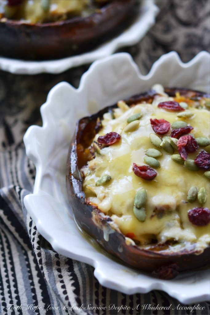 Chicken Enchilada Stuffed Acorn Squash - This warm autumn acorn squash dish is the perfect recipe to pull out to impress the guests at your next dinner party. Serve each guest half of an acorn squash filled with shredded chicken, green chile enchilada sauce, dried cranberries, and pepitas, topped with just the right amount of shredded cheddar cheese. Your guests will be begging you for the recipe afterward.