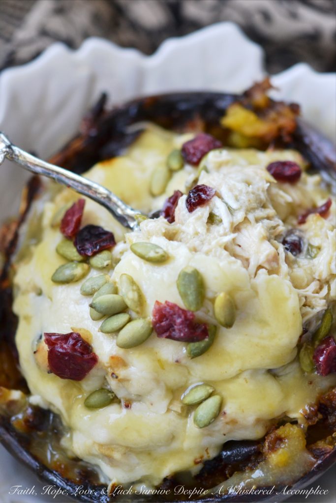 Chicken Enchilada Stuffed Acorn Squash - This warm autumn acorn squash dish is the perfect recipe to pull out to impress the guests at your next dinner party. Serve each guest half of an acorn squash filled with shredded chicken, green chile enchilada sauce, dried cranberries, and pepitas, topped with just the right amount of shredded cheddar cheese. Your guests will be begging you for the recipe afterward.
