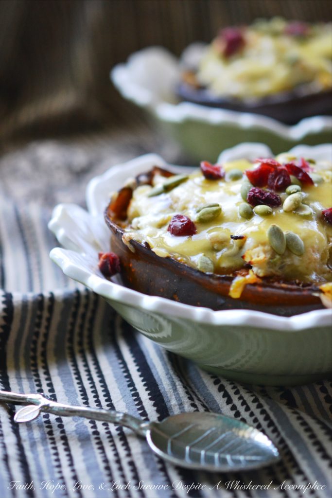 Chicken Enchilada Stuffed Acorn Squash - This warm autumn acorn squash dish is the perfect recipe to pull out to impress the guests at your next dinner party. Serve each guest half of an acorn squash filled with shredded chicken, green chile enchilada sauce, dried cranberries, and pepitas, topped with just the right amount of shredded cheddar cheese. Your guests will be begging you for the recipe afterward.