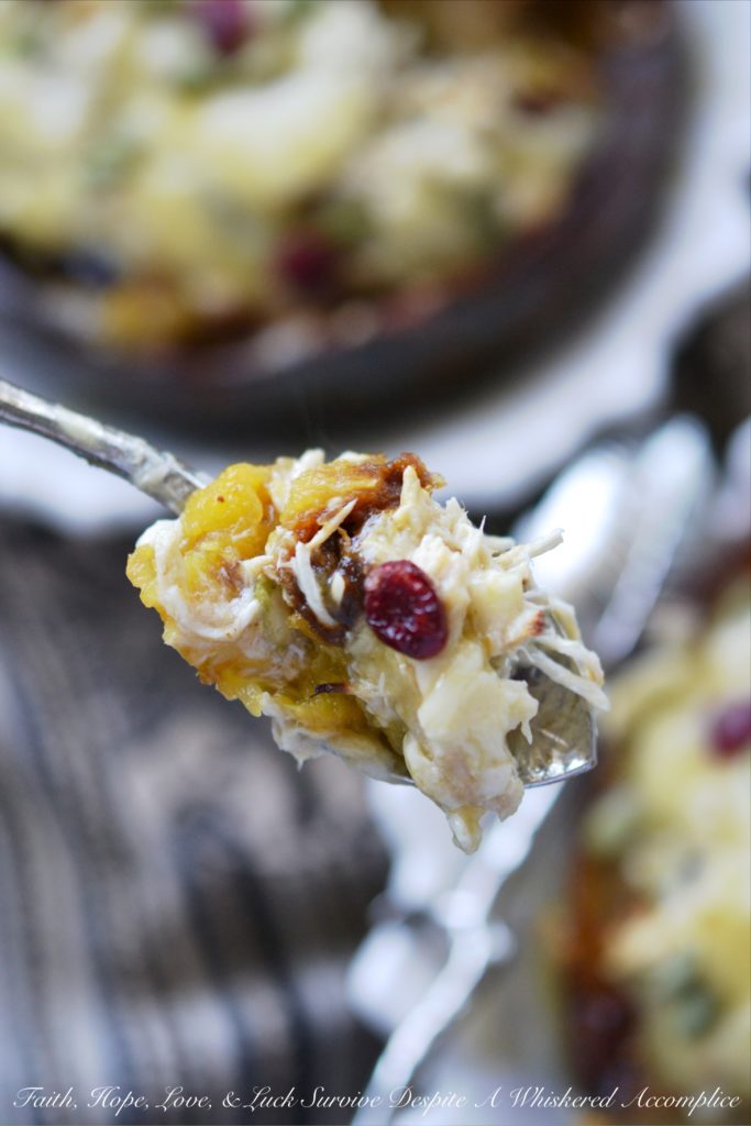 Chicken Enchilada Stuffed Acorn Squash - This warm autumn acorn squash dish is the perfect recipe to pull out to impress the guests at your next dinner party. Serve each guest half of an acorn squash filled with shredded chicken, green chile enchilada sauce, dried cranberries, and pepitas, topped with just the right amount of shredded cheddar cheese. Your guests will be begging you for the recipe afterward.