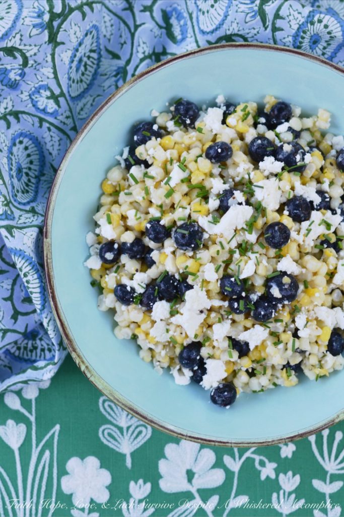 Fresh corn, plump blueberries, and feta cheese come together to make the perfect summer salad when combined with a white balsamic dressing.