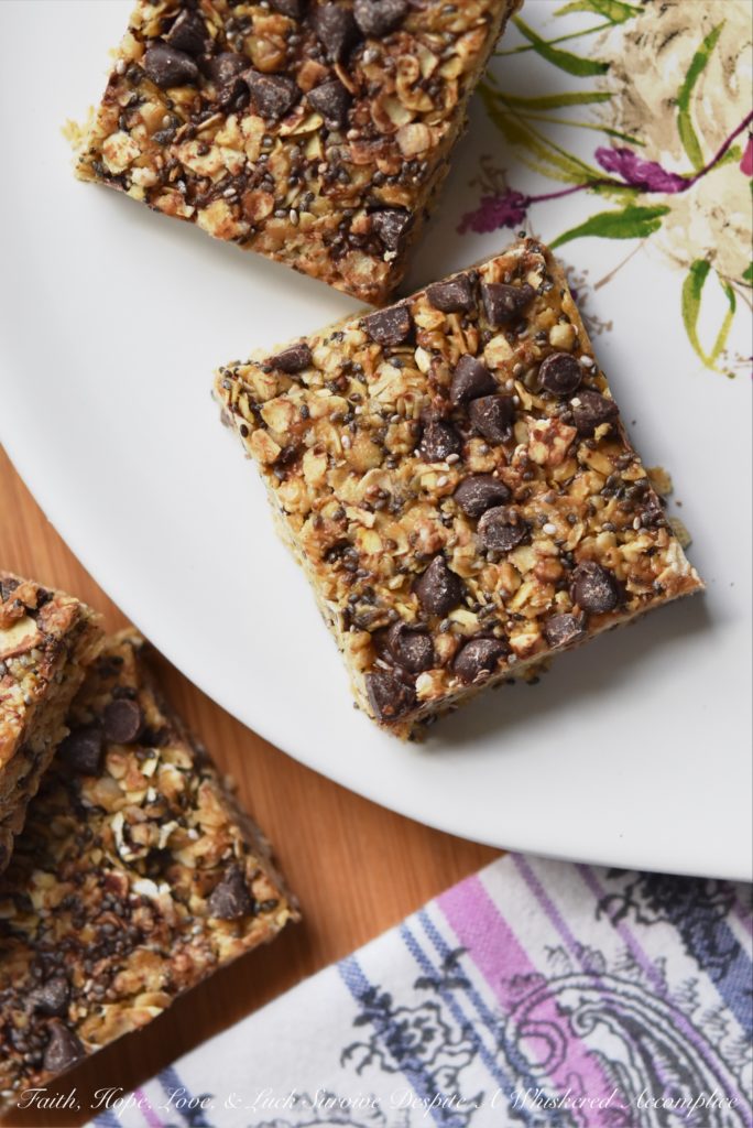Peanut Butter & Chocolate Chip Granola Squares - These healthier homemade granola squares are incredibly easy to make at home with just a few simple ingredients. You’ll love the chewy texture from quick-cooking oats, the boost of nutrition from chia seeds, and the satisfying flavor of creamy peanut butter. A drizzle of honey provides a touch of sweetness, and a scattering of mini chocolate chips makes them irresistibly good.