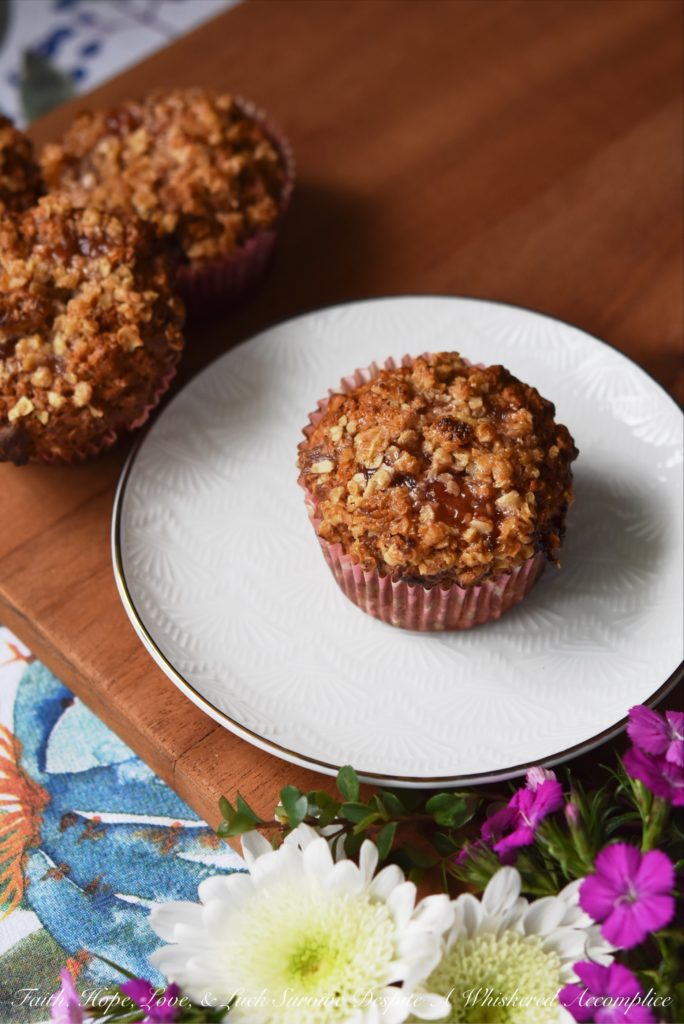 Strawberry Rhubarb Jam Oatmeal Muffins - Strawberry rhubarb jam lends a sweet fruity flavor to these delicious muffins sprinkled with just a touch of brown sugar, butter, and oatmeal crumble topping. The combination of jam and crunchy topping makes these muffins the perfect way to start your morning.