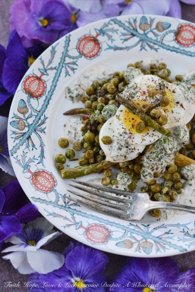 Creamy Roasted Asparagus & Pea Salad - This warm roasted vegetable salad uses fresh asparagus, frozen peas, and garlic to create an absolutely unforgettable spring salad. Topped with sliced hard-boiled eggs and a creamy parsley and chive dressing, this salad is anything but boring.