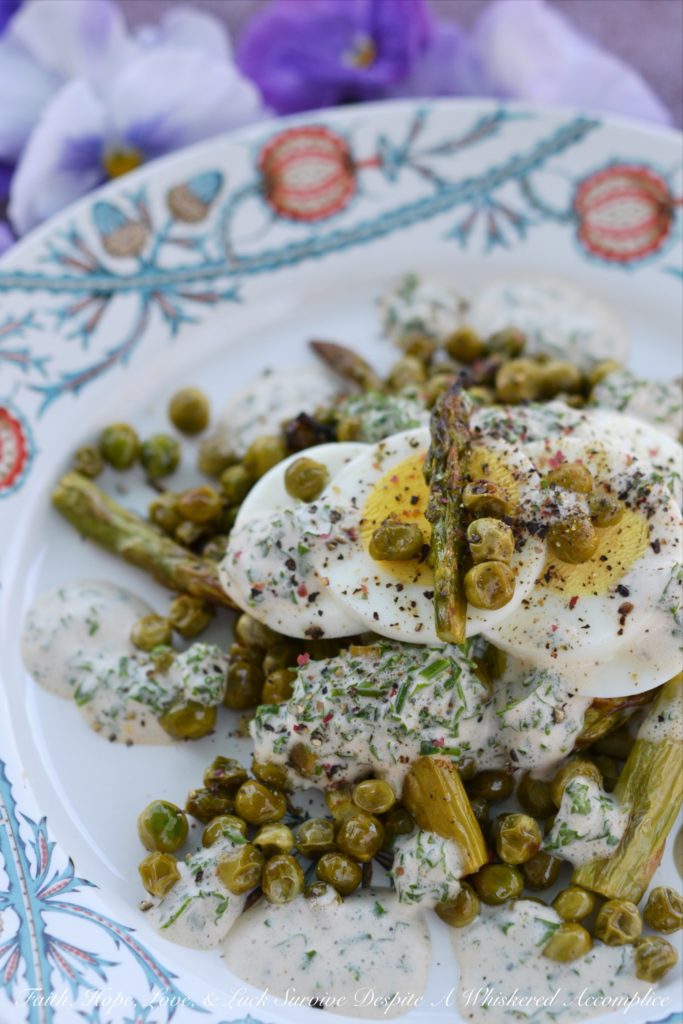 Creamy Roasted Asparagus & Pea Salad - This warm roasted vegetable salad uses fresh asparagus, frozen peas, and garlic to create an absolutely unforgettable spring salad. Topped with sliced hard-boiled eggs and a creamy parsley and chive dressing, this salad is anything but boring.