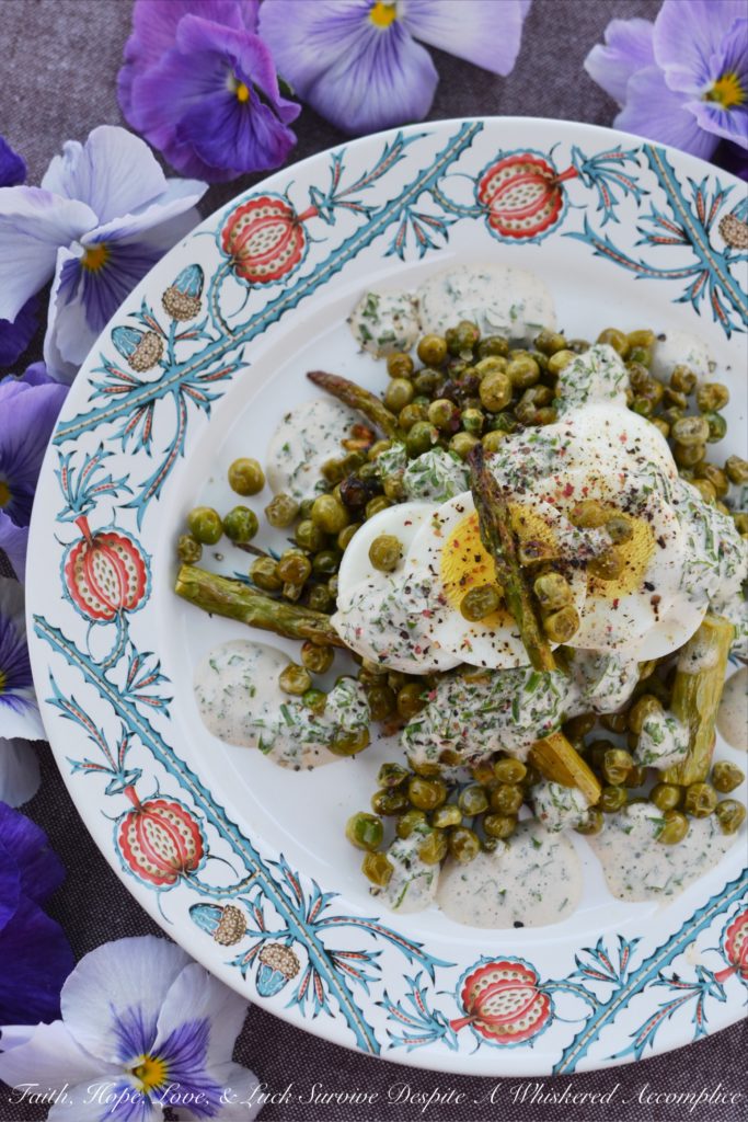 Creamy Roasted Asparagus & Pea Salad - This warm roasted vegetable salad uses fresh asparagus, frozen peas, and garlic to create an absolutely unforgettable spring salad. Topped with sliced hard-boiled eggs and a creamy parsley and chive dressing, this salad is anything but boring.