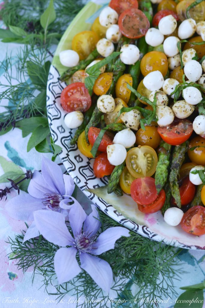 Grilled Asparagus Summer Caprese Salad - Grilled asparagus is topped with halved cherry tomatoes and fresh mozzarella in this room-temperature fresh summer salad. After being drizzled with a simple homemade balsamic vinegar dressing, this asparagus caprese salad instantly transforms into an appetizer, salad, or side dish perfect for your next BBQ, picnic, or cookout.
