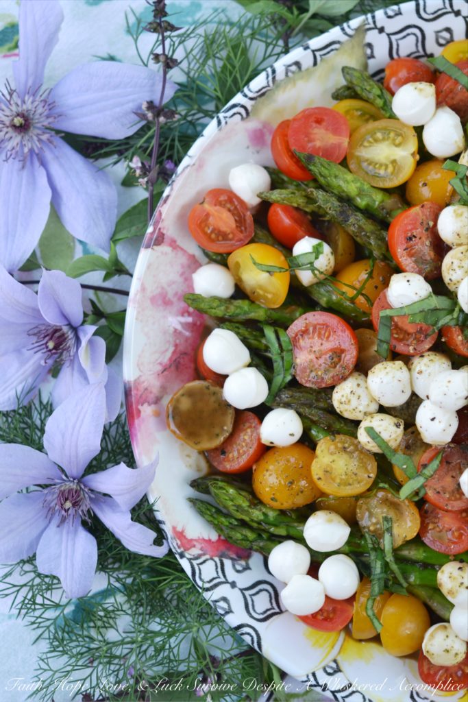 Grilled Asparagus Summer Caprese Salad - Grilled asparagus is topped with halved cherry tomatoes and fresh mozzarella in this room-temperature fresh summer salad. After being drizzled with a simple homemade balsamic vinegar dressing, this asparagus caprese salad instantly transforms into an appetizer, salad, or side dish perfect for your next BBQ, picnic, or cookout.