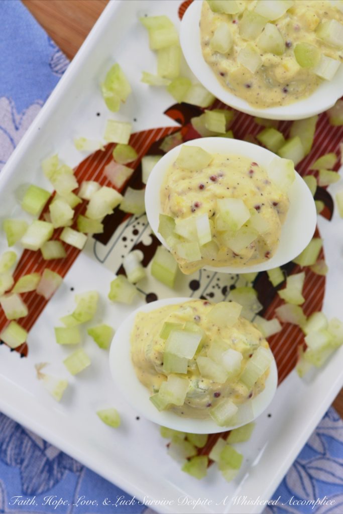 Celery & Whole Mustard Deviled Eggs - With five simple ingredients, you can kick up your deviled eggs this summer just in time to enjoy at your next cookout, picnic, or barbecue. These deviled eggs have a lovely crunch thanks to the finely diced celery both in the filling and used as a garnish, as well as tons of flavor from the whole Dijon mustard used to make the filling. These little guys are so simple to make but they are definitely anything but boring.