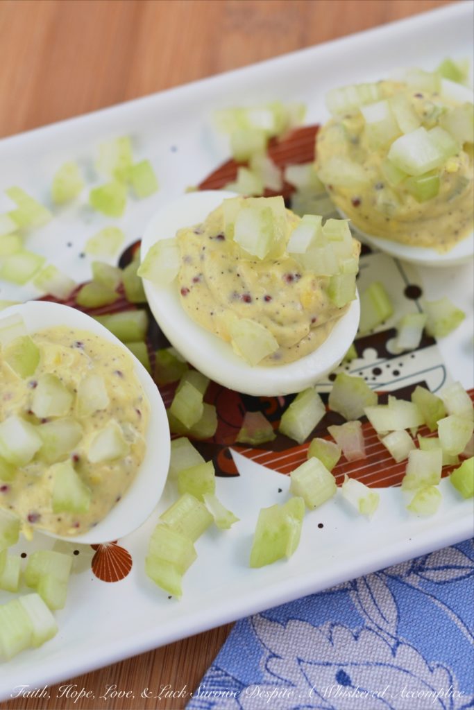 Celery & Whole Mustard Deviled Eggs - With five simple ingredients, you can kick up your deviled eggs this summer just in time to enjoy at your next cookout, picnic, or barbecue. These deviled eggs have a lovely crunch thanks to the finely diced celery both in the filling and used as a garnish, as well as tons of flavor from the whole Dijon mustard used to make the filling. These little guys are so simple to make but they are definitely anything but boring.