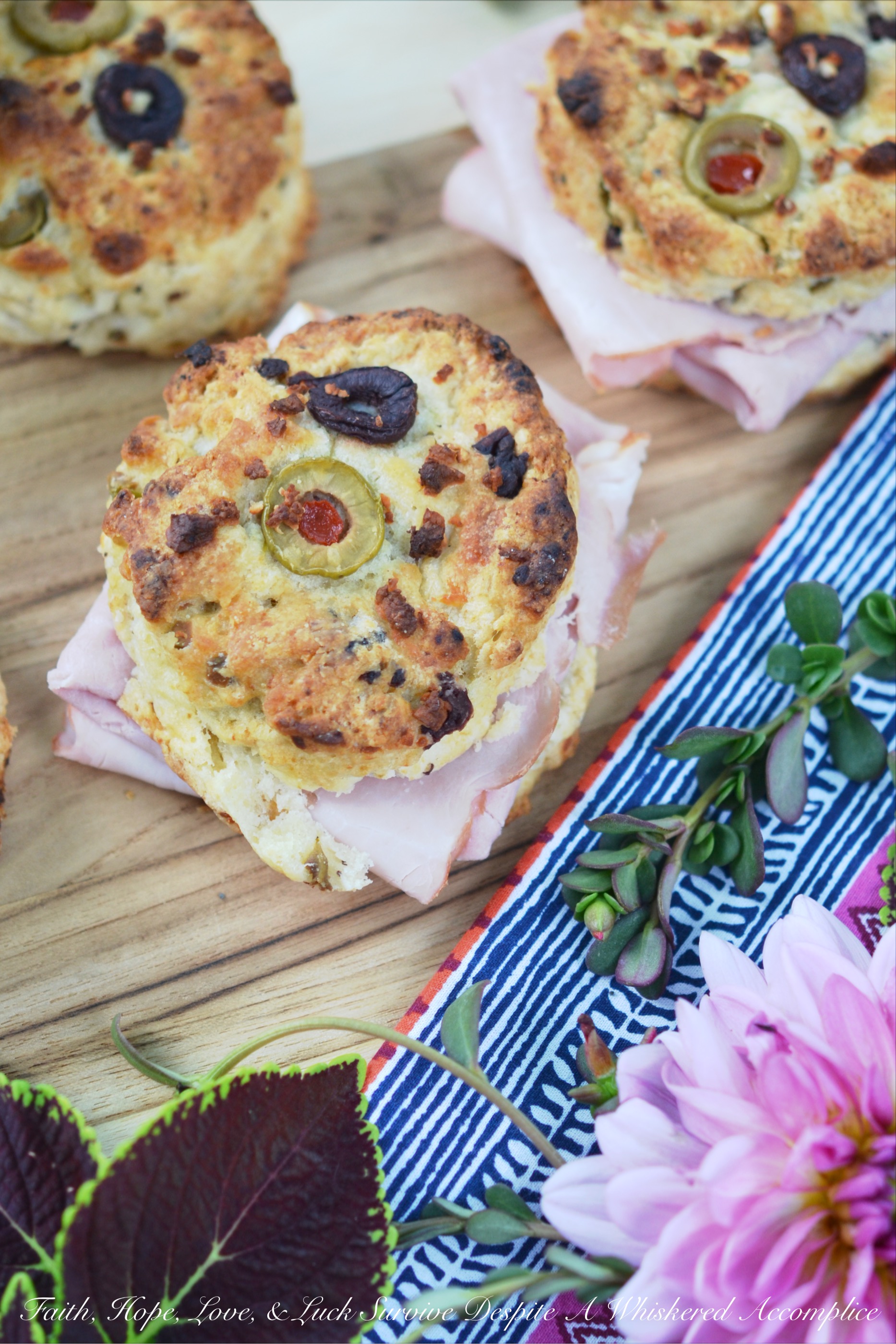 Olive & Feta Cheese Ham Biscuits - These southern ham biscuits are given a unique Mediterranean twist with the addition of olives and feta cheese. Whether you eat them for breakfast, lunch, or dinner, you're sure to enjoy these flavorful crumbly and buttery biscuit sandwiches.