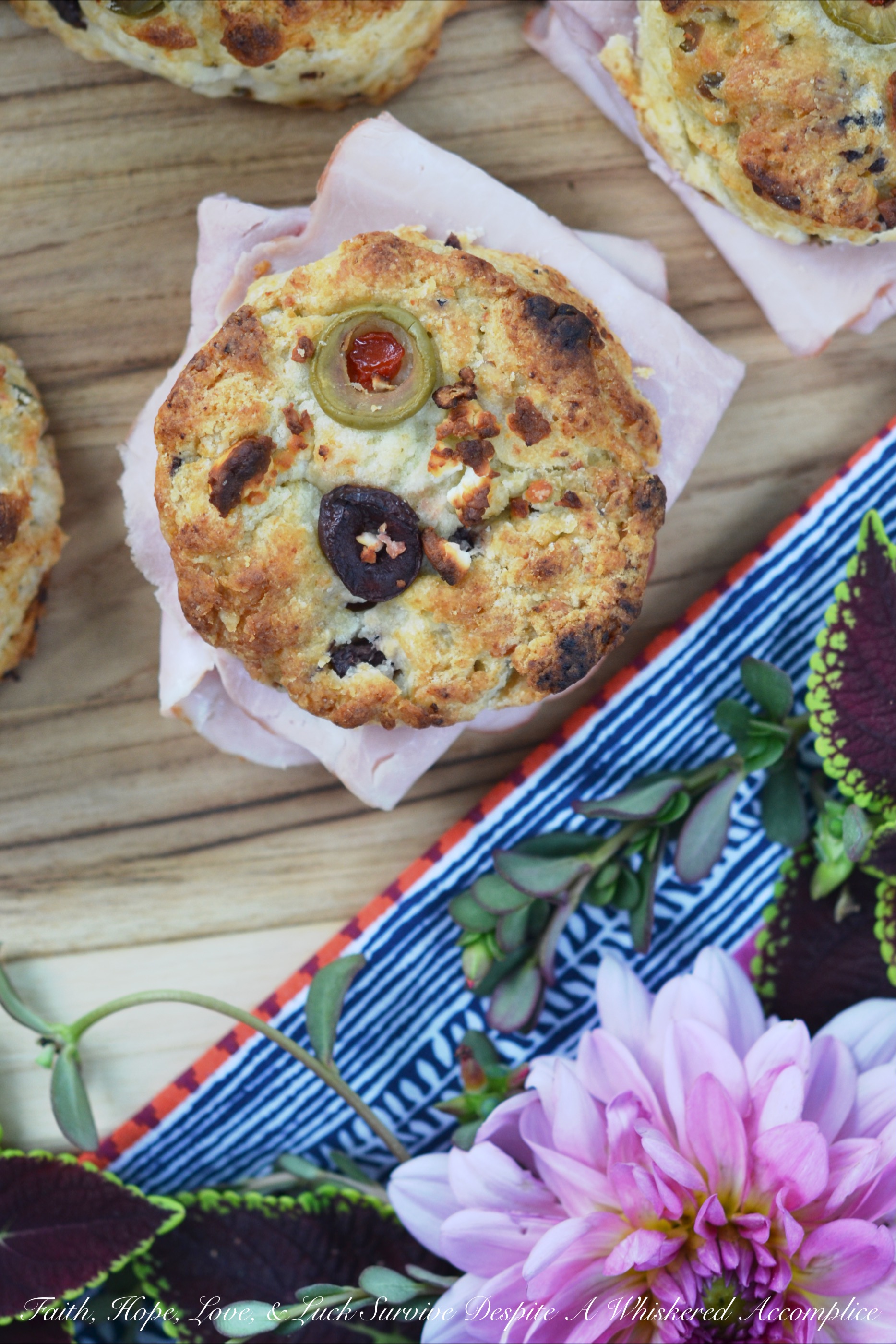 Olive & Feta Cheese Ham Biscuits - These southern ham biscuits are given a unique Mediterranean twist with the addition of olives and feta cheese. Whether you eat them for breakfast, lunch, or dinner, you're sure to enjoy these flavorful crumbly and buttery biscuit sandwiches.