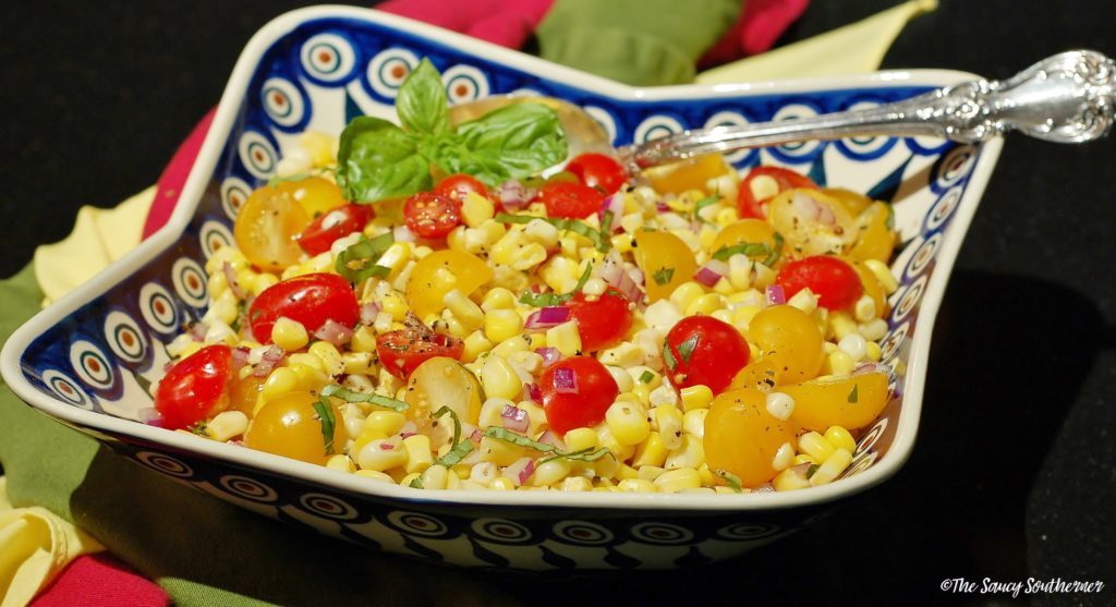 Corn and Tomato Salad - The Saucy Southerner - August 2018 Recipe Round-Up - For the month of August, we're sharing all of our favorite summertime recipes to make for a backyard barbecue, picnic, or cookout. After all, the warm summer weather won't stick around forever, so we need to spend as much time outdoors as possible before autumn arrives.