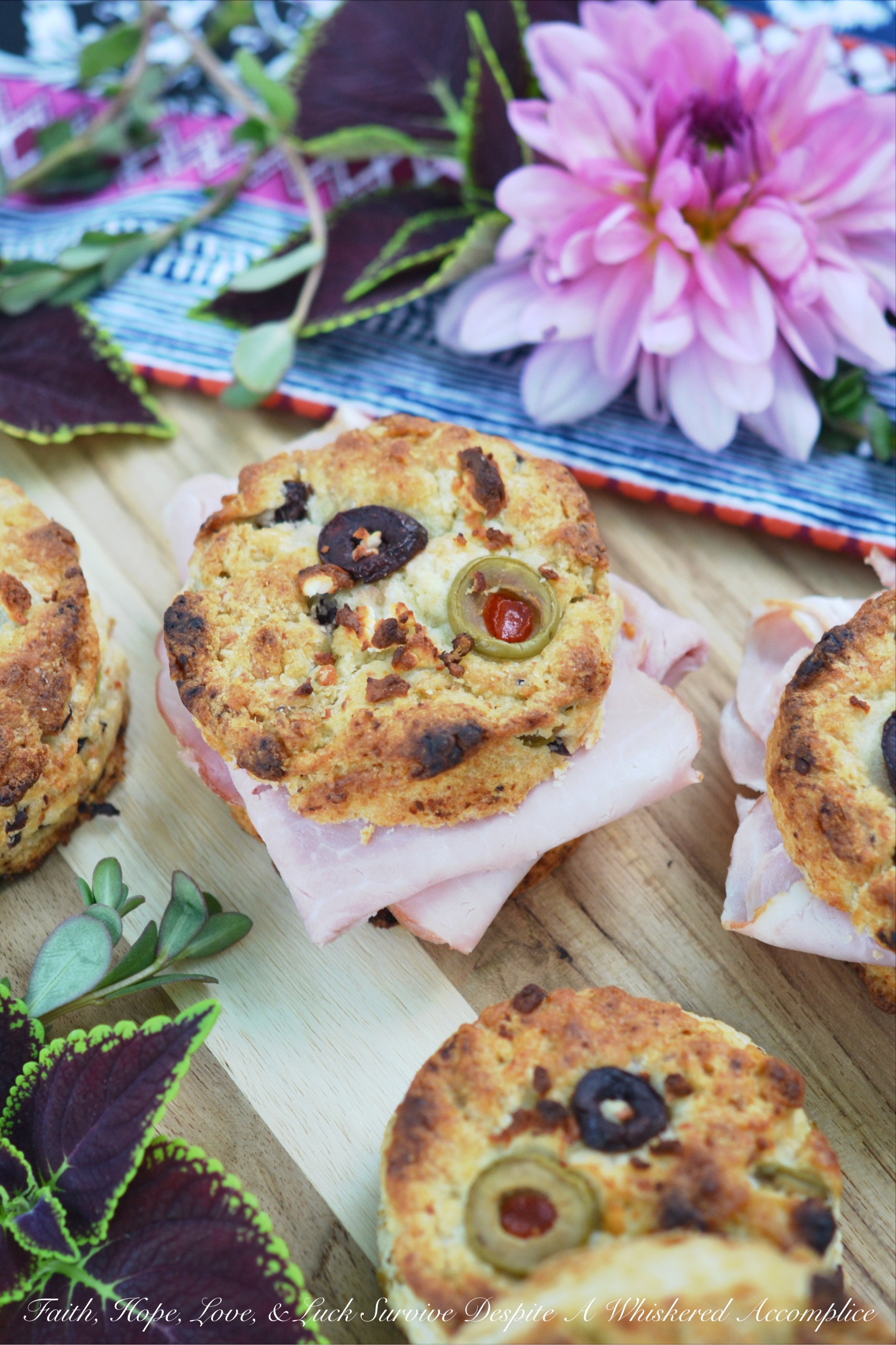 Olive & Feta Cheese Ham Biscuits - These southern ham biscuits are given a unique Mediterranean twist with the addition of olives and feta cheese. Whether you eat them for breakfast, lunch, or dinner, you're sure to enjoy these flavorful crumbly and buttery biscuit sandwiches.