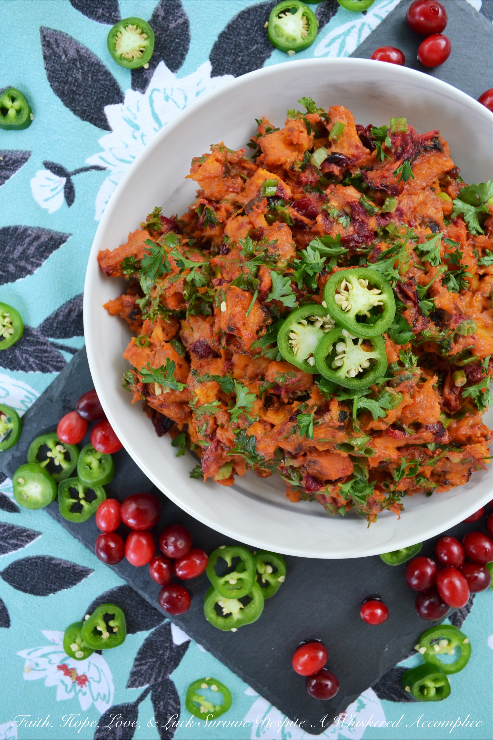 Warm Cranberry & Jalapeño Sweet Potato Salad - This warm side salad is made using oven-roasted sweet potatoes and cranberries, which are tossed in a sweet and spicy sauce, along with chopped scallions, finely diced jalapeño, and fresh parsley. This unique and flavorful summer potato salad just goes to show you that sweet potatoes and cranberries aren't just for Thanksgiving anymore.