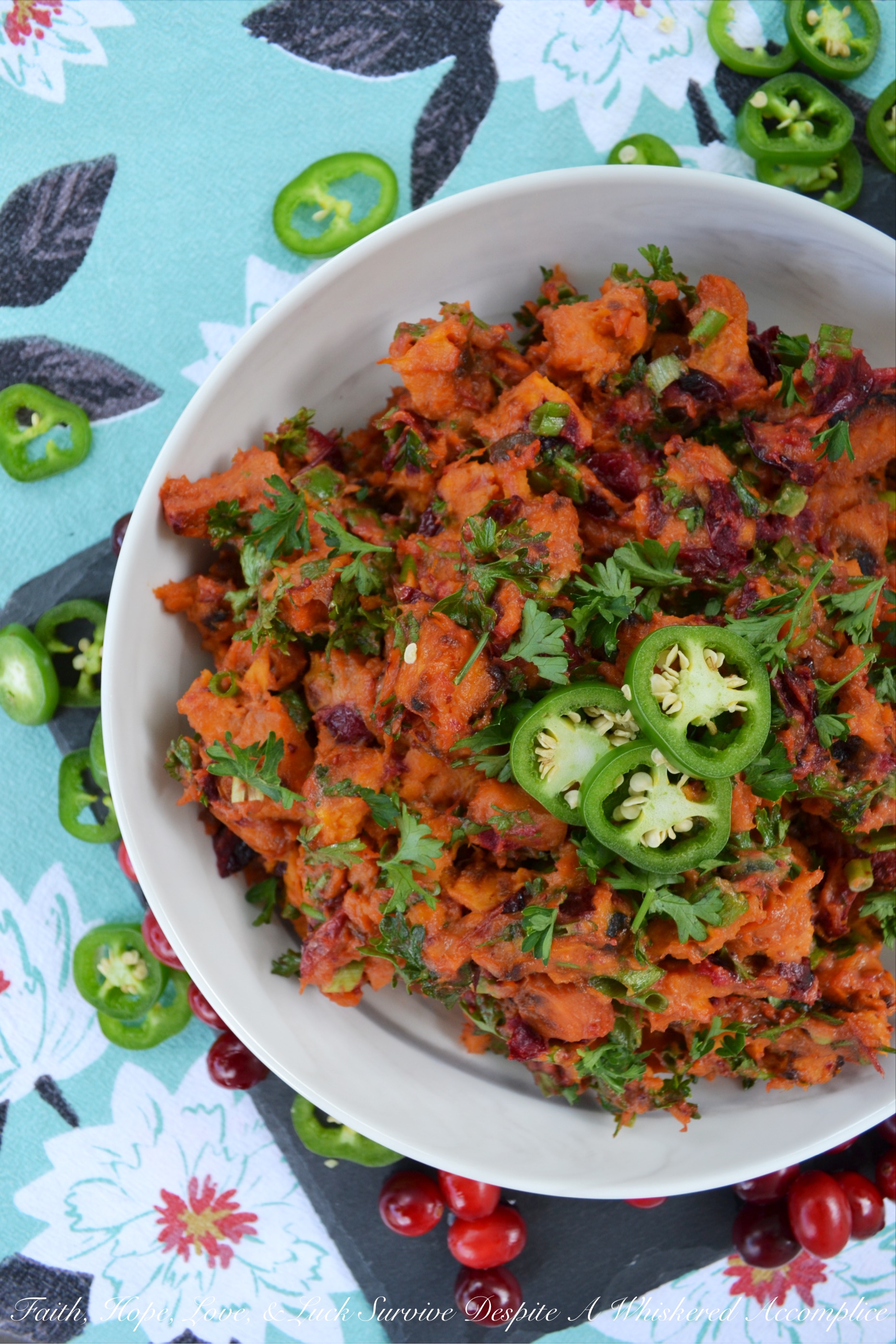 Warm Cranberry & Jalapeño Sweet Potato Salad - This warm side salad is made using oven-roasted sweet potatoes and cranberries, which are tossed in a sweet and spicy sauce, along with chopped scallions, finely diced jalapeño, and fresh parsley. This unique and flavorful summer potato salad just goes to show you that sweet potatoes and cranberries aren't just for Thanksgiving anymore.
