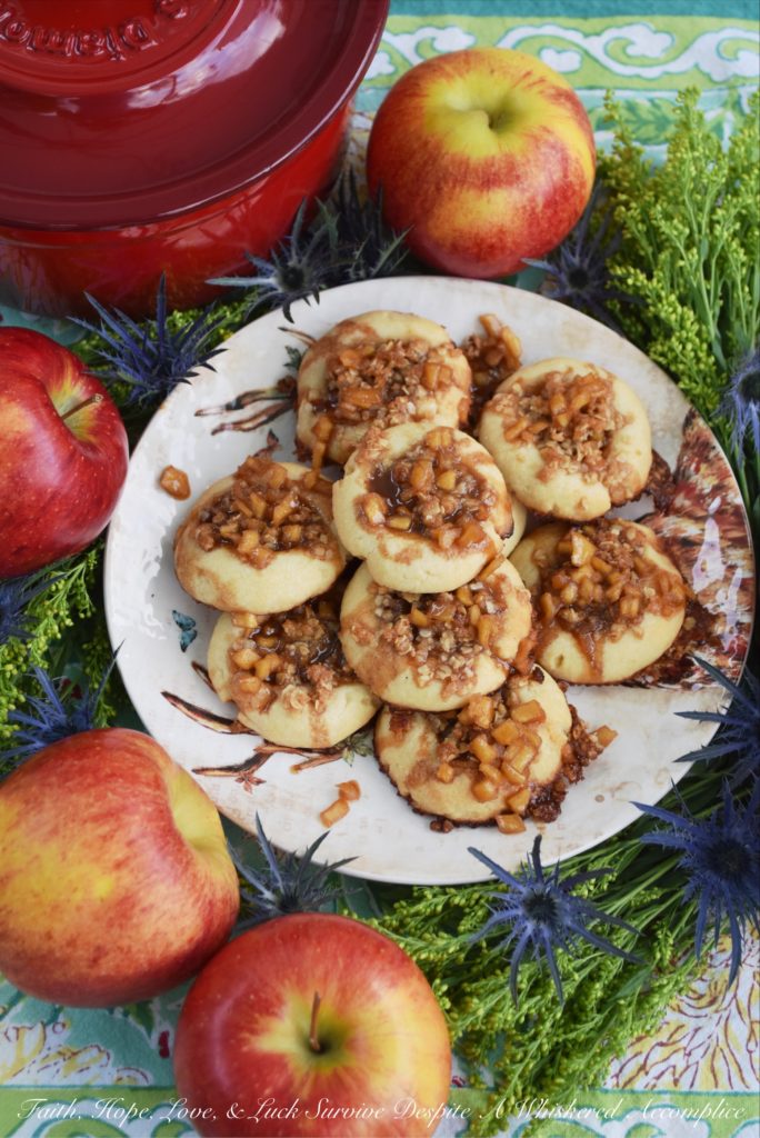 Buttery Apple Streusel Thumbprint Cookies - What's better than a cookie? A buttery cookie, filled with cinnamon caramel apple sauce, topped with sweet oatmeal streusel topping, and then drizzled with more cinnamon caramel apple sauce. Are you drooling yet? I know I am. Really, this is simply one thumbprint cookie you just have to make this fall.