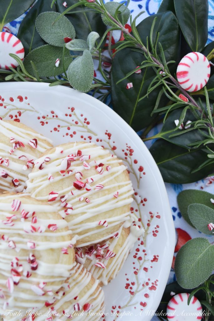 White Christmas Peppermint Holiday Cookies - Not only do these peppermint holiday cookies practically melt in your mouth, but due to their flaky texture, they almost crumble apart at the gentlest touch. Thankfully the white chocolate they are drizzled with helps keep them together just long enough for you to get them from your hand to your mouth. Sure there may be a few crumbs dropped during the process, but who can't live with a few crumbs at Christmas time?