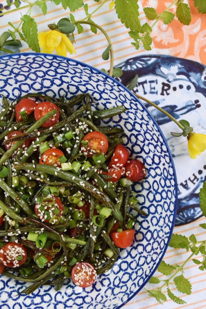 Roasted Asian Green Bean Salad with Tomatoes - When summer hits, it always seems to bring an excess of summer vegetables for us to deal with. This flavorful roasted green bean salad uses Asian flavors to create a unique and delicious side salad to help you use up some of those fresh garden green beans and cherry tomatoes before they go bad.