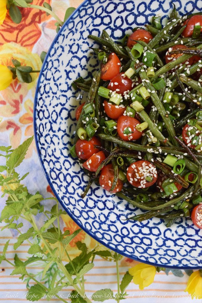 Roasted Asian Green Bean Salad with Tomatoes - When summer hits, it always seems to bring an excess of summer vegetables for us to deal with. This flavorful roasted green bean salad uses Asian flavors to create a unique and delicious side salad to help you use up some of those fresh garden green beans and cherry tomatoes before they go bad.