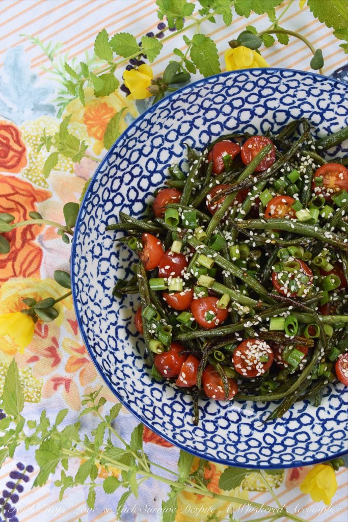 Roasted Asian Green Bean Salad with Tomatoes - When summer hits, it always seems to bring an excess of summer vegetables for us to deal with. This flavorful roasted green bean salad uses Asian flavors to create a unique and delicious side salad to help you use up some of those fresh garden green beans and cherry tomatoes before they go bad.
