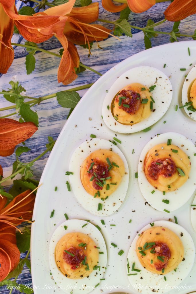 Deviled Eggs with Red Chili Garlic Sauce - These deviled eggs are just about the most exciting thing to happen to your summer. I can honestly say that they're even more spectacular than a 4th of July fireworks show. Yup, they're that good, thanks to the homemade sweet and spicy red chili garlic sauce used in their filling and as a garnish. They're practically exploding with flavor.