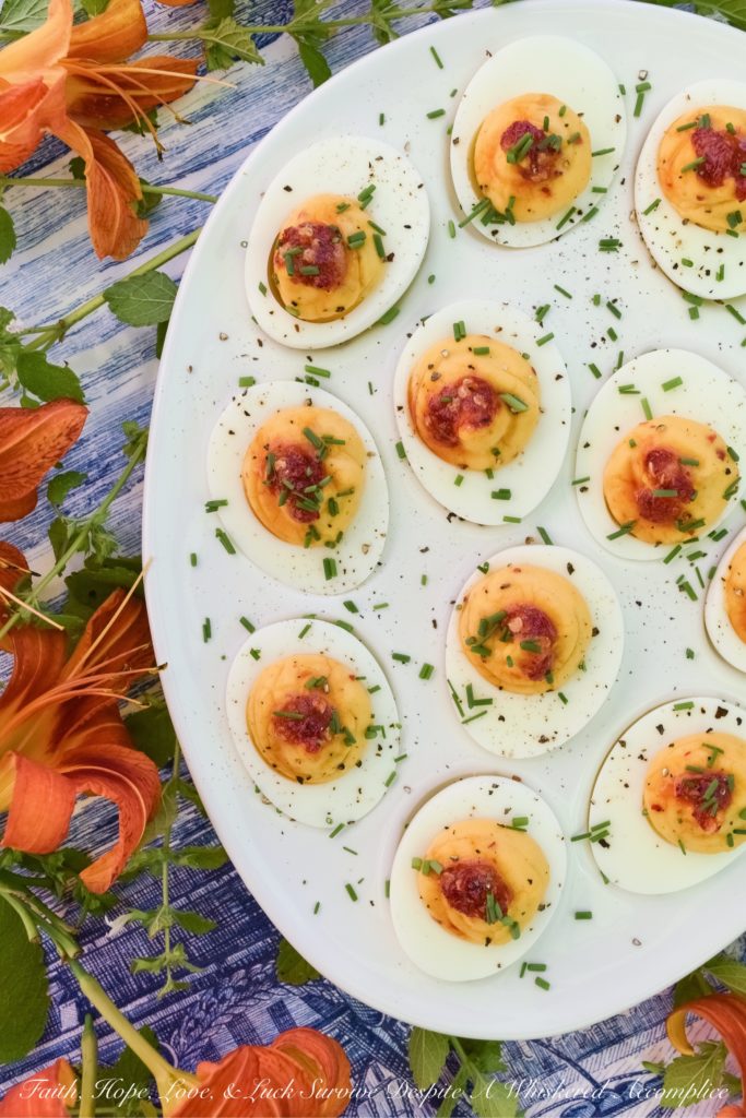 Deviled Eggs with Red Chili Garlic Sauce - These deviled eggs are just about the most exciting thing to happen to your summer. I can honestly say that they're even more spectacular than a 4th of July fireworks show. Yup, they're that good, thanks to the homemade sweet and spicy red chili garlic sauce used in their filling and as a garnish. They're practically exploding with flavor.