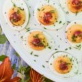Deviled Eggs with Red Chili Garlic Sauce - These deviled eggs are just about the most exciting thing to happen to your summer. I can honestly say that they're even more spectacular than a 4th of July fireworks show. Yup, they're that good, thanks to the homemade sweet and spicy red chili garlic sauce used in their filling and as a garnish. They're practically exploding with flavor.