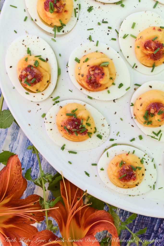 Deviled Eggs with Red Chili Garlic Sauce - These deviled eggs are just about the most exciting thing to happen to your summer. I can honestly say that they're even more spectacular than a 4th of July fireworks show. Yup, they're that good, thanks to the homemade sweet and spicy red chili garlic sauce used in their filling and as a garnish. They're practically exploding with flavor.