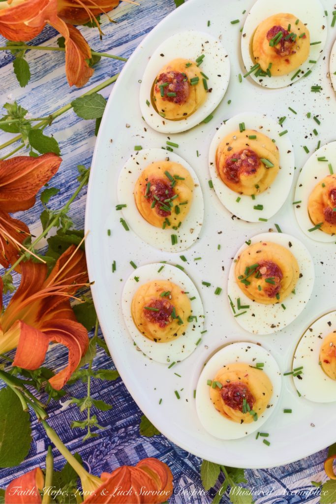 Deviled Eggs with Red Chili Garlic Sauce - These deviled eggs are just about the most exciting thing to happen to your summer. I can honestly say that they're even more spectacular than a 4th of July fireworks show. Yup, they're that good, thanks to the homemade sweet and spicy red chili garlic sauce used in their filling and as a garnish. They're practically exploding with flavor.