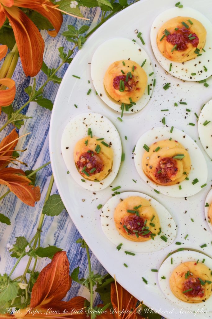 Deviled Eggs with Red Chili Garlic Sauce - These deviled eggs are just about the most exciting thing to happen to your summer. I can honestly say that they're even more spectacular than a 4th of July fireworks show. Yup, they're that good, thanks to the homemade sweet and spicy red chili garlic sauce used in their filling and as a garnish. They're practically exploding with flavor.