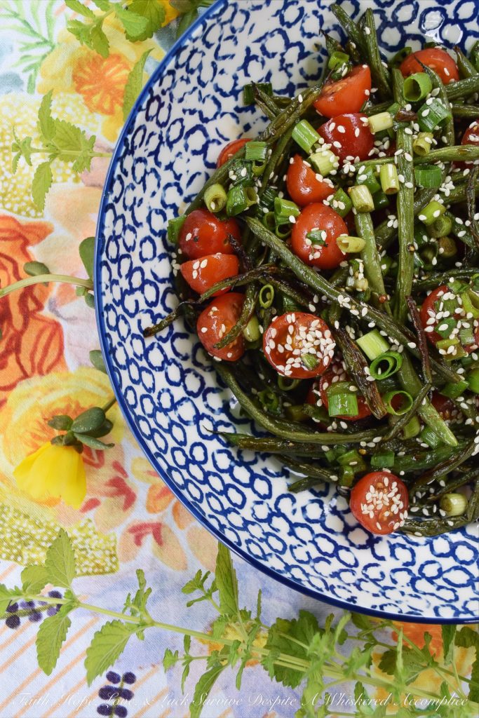 Roasted Asian Green Bean Salad with Tomatoes - When summer hits, it always seems to bring an excess of summer vegetables for us to deal with. This flavorful roasted green bean salad uses Asian flavors to create a unique and delicious side salad to help you use up some of those fresh garden green beans and cherry tomatoes before they go bad.