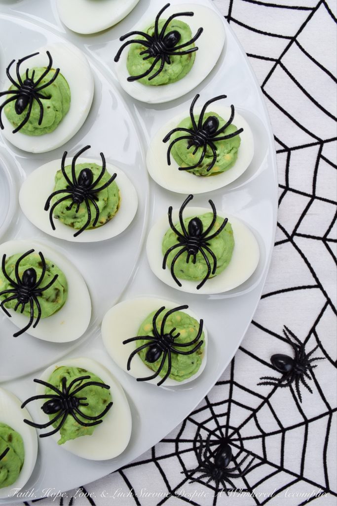 Halloween Monster Mash Jalapeño Deviled Eggs - These sweet and spicy monster mash deviled eggs are the perfect party treat to share with your ghouls and goblins this Halloween season. Finely diced candied jalapeños are the secret to their amazing flavor. Add in a bit of green food coloring and a spider garnish on top for just the right festive holiday touch.