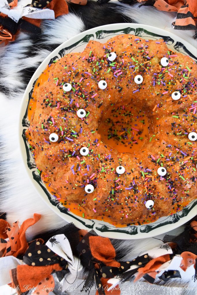 Halloween-Inspired Orange Ricotta Bundt Cake - The secret to this light, moist, and airy Bundt cake is the ricotta cheese it contains, as well as the added orange zest and juice, which help give it a lovely citrus flavor. Topping it with an orange powdered sugar glaze, followed by festive Halloween sprinkles and candy eyeballs, also helps to give this holiday cake the perfect touch of spooky cuteness.