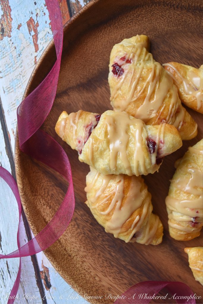 Cranberry Crescent Rolls with Maple Icing - A little leftover cranberry sauce goes a long way when used in these light and airy cranberry crescent rolls drizzled with maple icing. So this Thanksgiving, make sure you have enough cranberry sauce to make these for breakfast. They're the perfect way to start off the holiday and you'll love how fast, simple, and delicious they are.