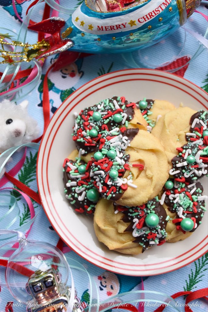 Chocolate-Dipped Christmas Butter Cookies - What's better than a holiday butter cookie? A festive Christmas holiday butter cookie dipped in chocolate and covered with sprinkles. Yup, chocolate-dipped butter cookies definitely make the holidays worth celebrating.