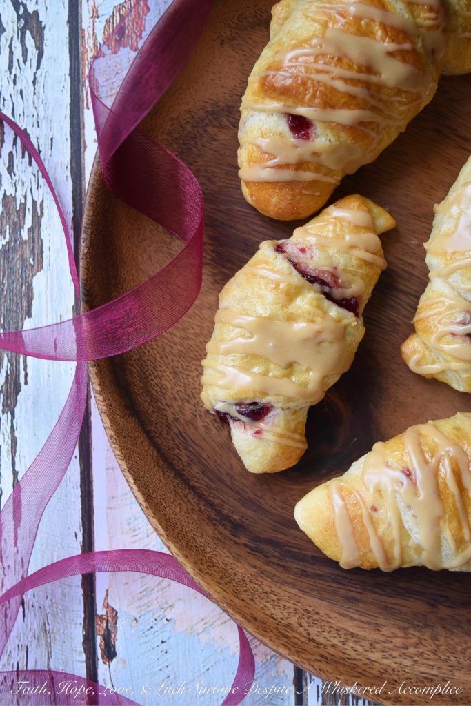 Cranberry Crescent Rolls with Maple Icing - A little leftover cranberry sauce goes a long way when used in these light and airy cranberry crescent rolls drizzled with maple icing. So this Thanksgiving, make sure you have enough cranberry sauce to make these for breakfast. They're the perfect way to start off the holiday and you'll love how fast, simple, and delicious they are.