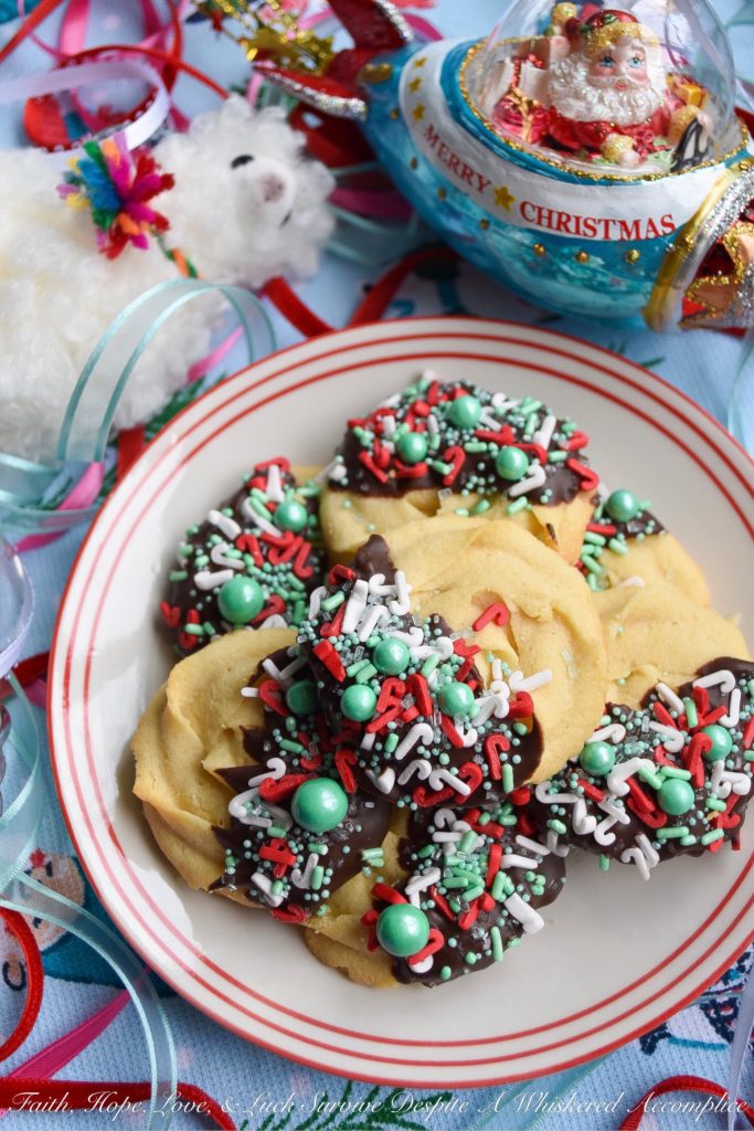 Chocolate-Dipped Christmas Butter Cookies - What's better than a holiday butter cookie? A festive Christmas holiday butter cookie dipped in chocolate and covered with sprinkles. Yup, chocolate-dipped butter cookies definitely make the holidays worth celebrating.