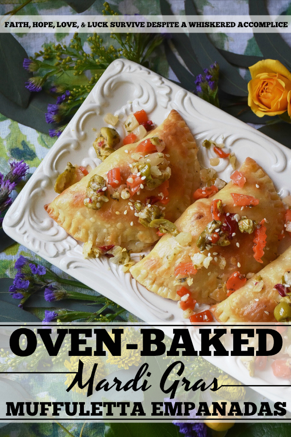 Oven-Baked Mardi Gras Muffuletta Empanadas - Looking to celebrate Mardi Gras with a unique and festive appetizer? Then these oven-baked muffuletta empanadas are just what you're looking for. Each empanada is stuffed with capicola, mortadella, salami, provolone cheese, and just the tiniest bit of Italian olive spread. After they are baked to golden brown perfection, you simply serve them topped with additional Italian olive spread and a light sprinkling of sesame seeds.