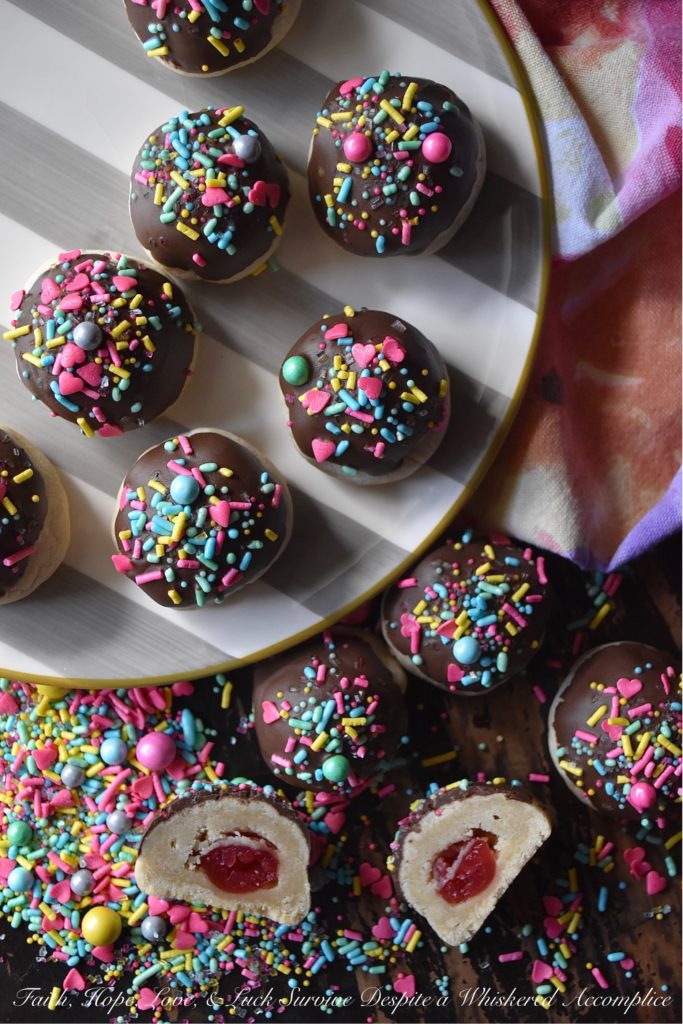 Chocolate-Covered Cherry Bon Bon Cookies - These heavenly chocolate-covered bon bon cookies are filled with a sweet surprise. Tucked inside each one is a maraschino cherry, just waiting for you to discover it. And, after each cookie is dipped in melted dark chocolate and topped generously with sprinkles, I think you'll agree that these amazing cookies are pretty hard to resist.