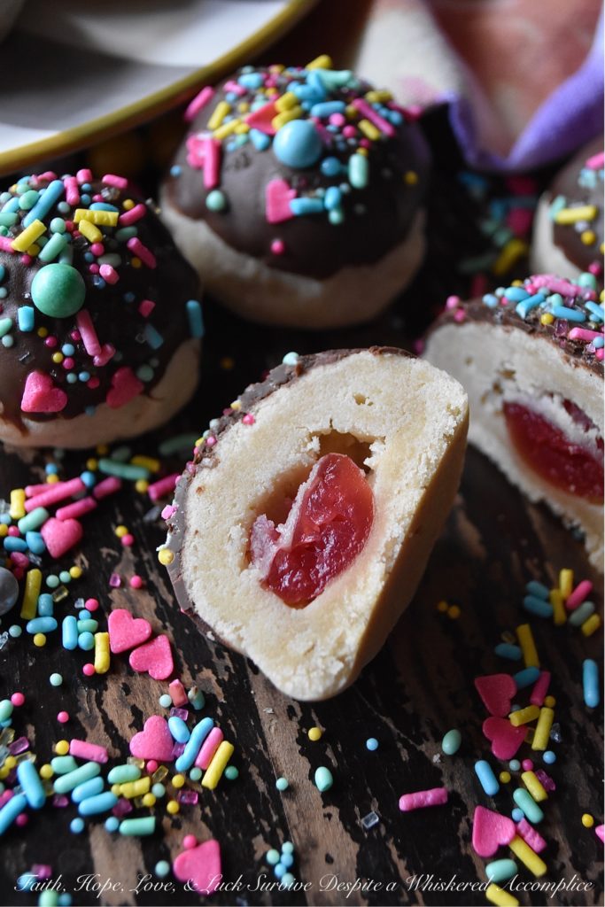 Chocolate-Covered Cherry Bon Bon Cookies - These heavenly chocolate-covered bon bon cookies are filled with a sweet surprise. Tucked inside each one is a maraschino cherry, just waiting for you to discover it. And, after each cookie is dipped in melted dark chocolate and topped generously with sprinkles, I think you'll agree that these amazing cookies are pretty hard to resist.