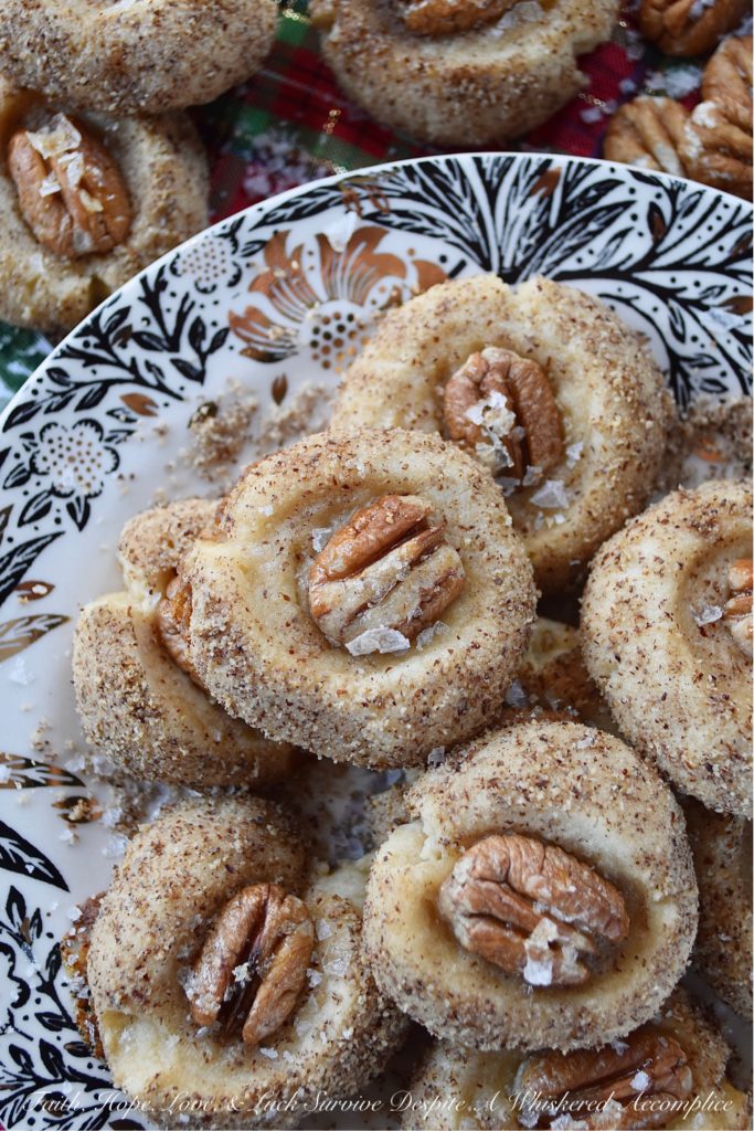 Salted Honey Pecan Thumbprint Cookies - What could be better than a buttery thumbprint cookie? A buttery thumbprint cookie rolled in finely ground pecans, topped with a pecan half, and then drizzled with just the right touch of sweet honey and a light sprinkle of flaky sea salt. This is one sweet and salty thumbprint cookie you simply won't be able to resist.