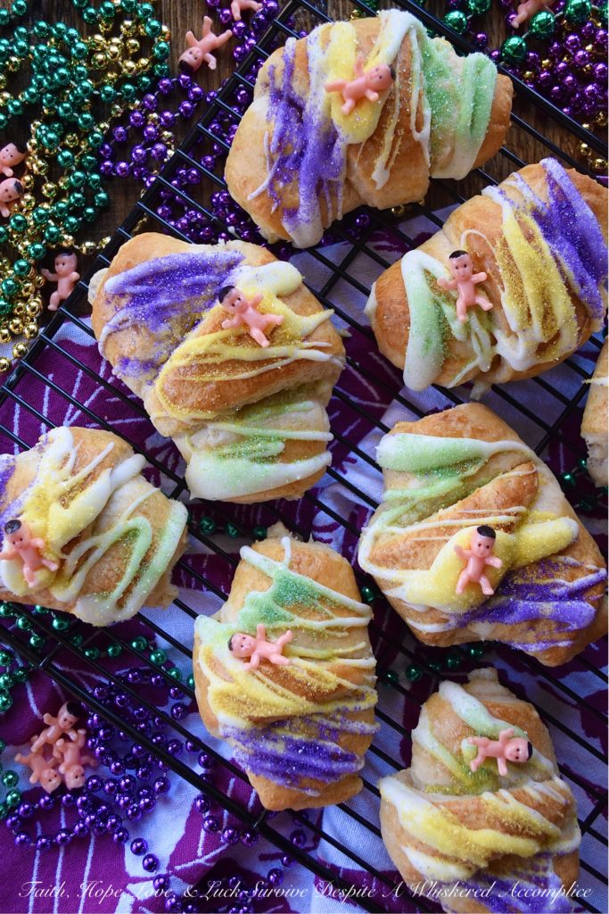 Mardi Gras Cream Cheese King Cake Croissants - Unable to find a king cake to celebrate Mardi Gras this year? With these cream cheese croissants, made using refrigerated crescent rolls, you'll be able to celebrate the holiday with very little effort involved. And, once you decorate each king cake croissant with some yellow, green, and purple sanding sugar and a small plastic Mardi Gras baby, you'll have a festive treat everyone in your family will love. Laissez les bons temps rouler.
