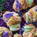 Mardi Gras Cream Cheese King Cake Croissants - Unable to find a king cake to celebrate Mardi Gras this year? With these cream cheese croissants, made using refrigerated crescent rolls, you'll be able to celebrate the holiday with very little effort involved. And, once you decorate each king cake croissant with some yellow, green, and purple sanding sugar and a small plastic Mardi Gras baby, you'll have a festive treat everyone in your family will love. Laissez les bons temps rouler.
