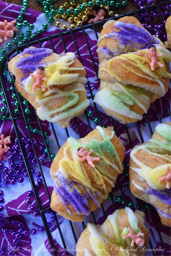 Mardi Gras Cream Cheese King Cake Croissants - Unable to find a king cake to celebrate Mardi Gras this year? With these cream cheese croissants, made using refrigerated crescent rolls, you'll be able to celebrate the holiday with very little effort involved. And, once you decorate each king cake croissant with some yellow, green, and purple sanding sugar and a small plastic Mardi Gras baby, you'll have a festive treat everyone in your family will love. Laissez les bons temps rouler.