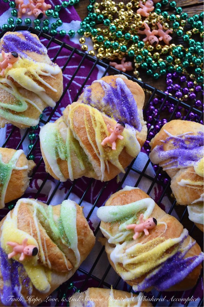 Mardi Gras Cream Cheese King Cake Croissants - Unable to find a king cake to celebrate Mardi Gras this year? With these cream cheese croissants, made using refrigerated crescent rolls, you'll be able to celebrate the holiday with very little effort involved. And, once you decorate each king cake croissant with some yellow, green, and purple sanding sugar and a small plastic Mardi Gras baby, you'll have a festive treat everyone in your family will love. Laissez les bons temps rouler.