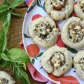 Savory Cherry Tomato, Basil, & Feta Cookies - This savory thumbprint cookie recipe is perfect for summer when fresh tomatoes and fresh basil are at their prime. The cookie dough is just a little bit sweet, while the feta cheese filling has the perfect amount of saltiness to balance out the flavor of the fresh cherry tomato it is baked on top of. Now sure, you could absolutely put this same feta and basil filling on top of baked bread all summer long, but why do that, when you can have it on top of a savory cookie instead?